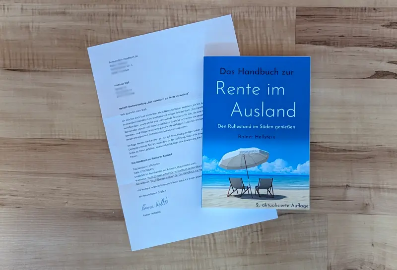 Das Bild zeigt das Anschreiben des Autors und das Buch zum Thema Rente im Ausland. Beides liegt auf einem Holzhintergrund.